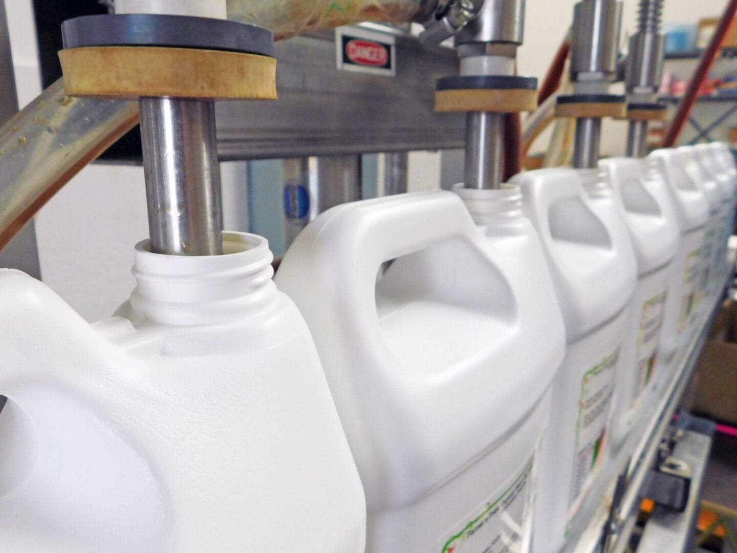 A row of white milk jugs lined up next to each other.